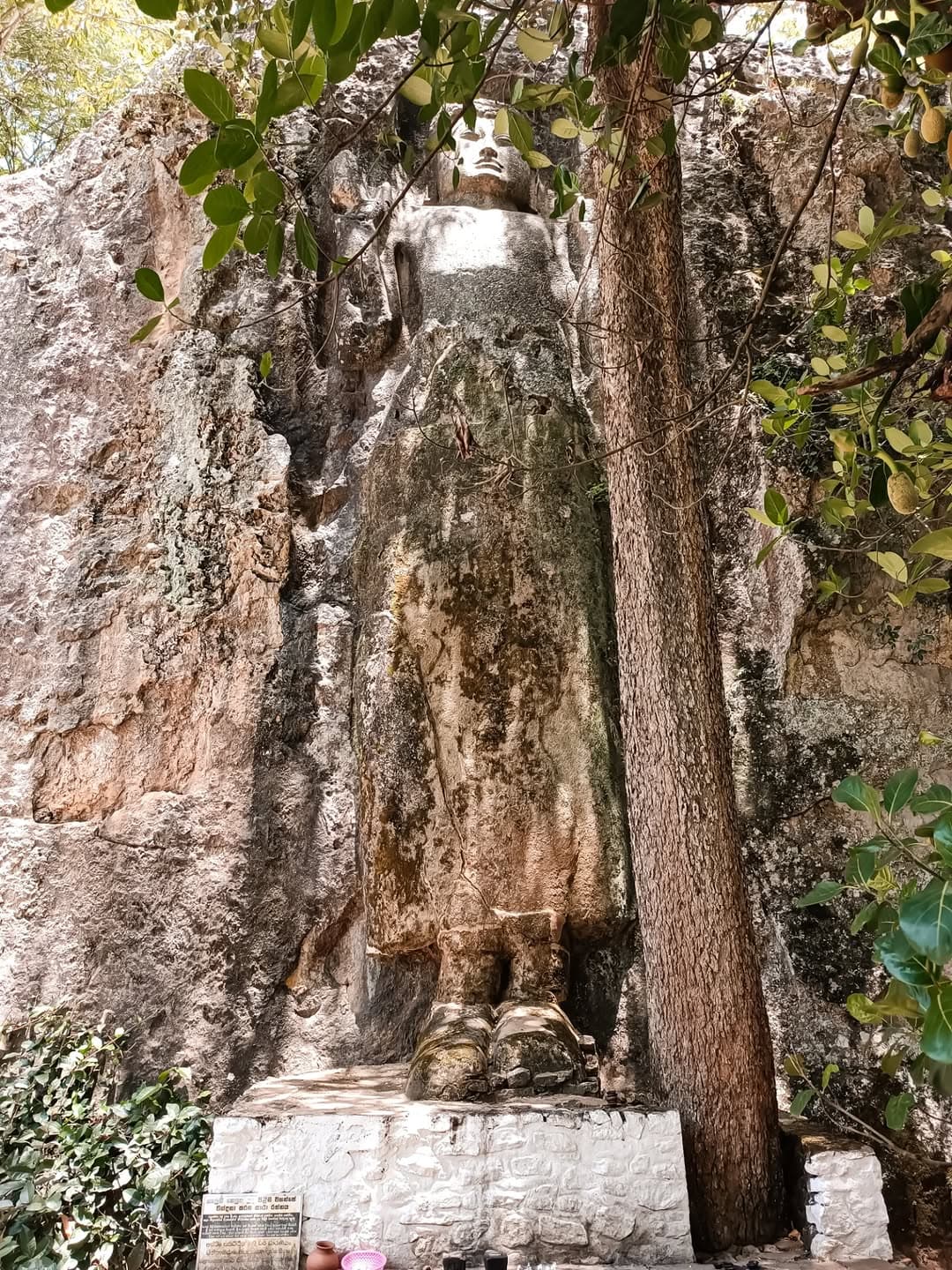 Ancient Dhowa Rock Temple with unfinished Buddha carving and cave shrines