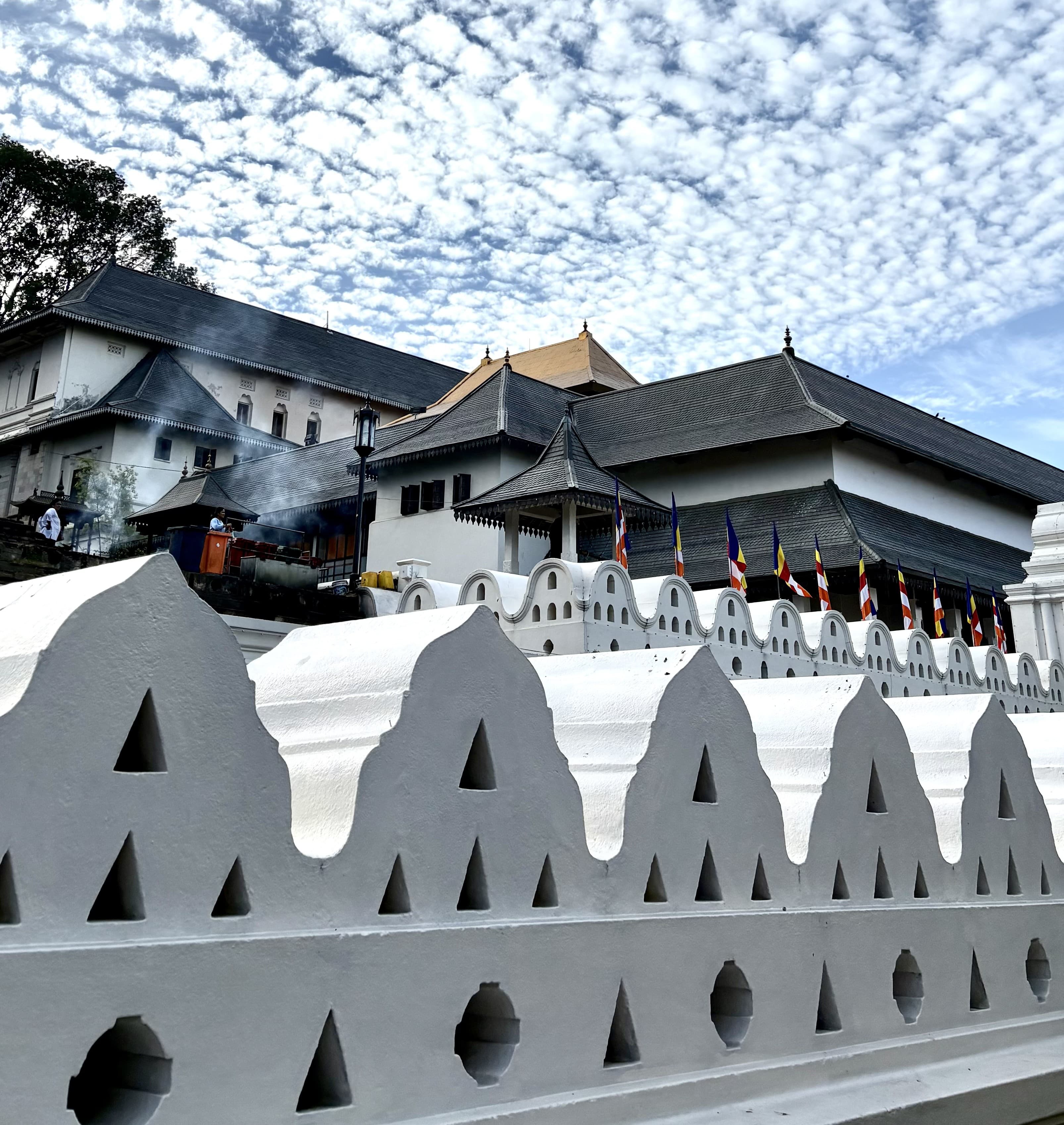 Temple of the Tooth Kandy with golden roof and traditional architecture beside Kandy Lake