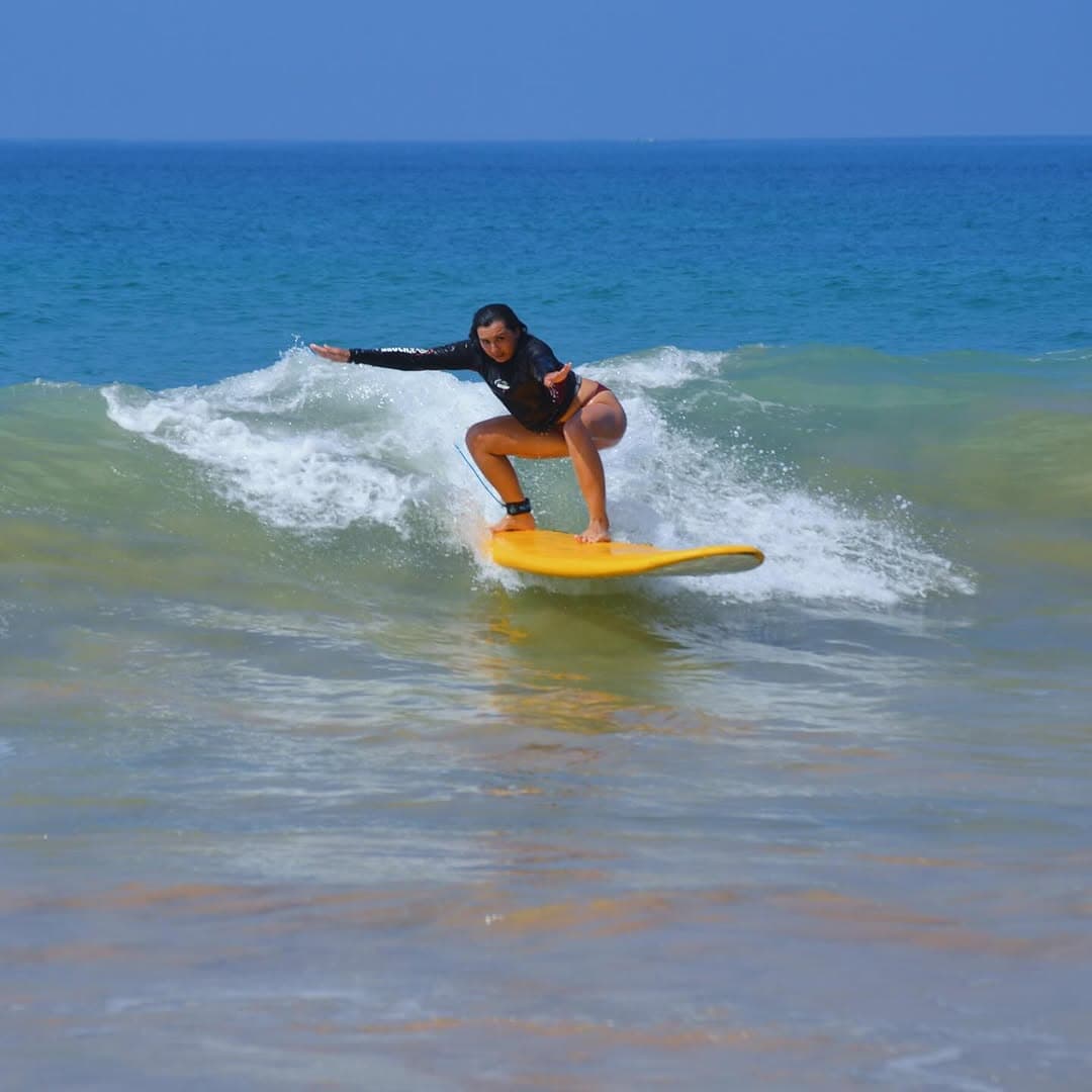 Surfing lessons at Weligama Bay with beginner surfers learning on gentle waves with instructor guidance