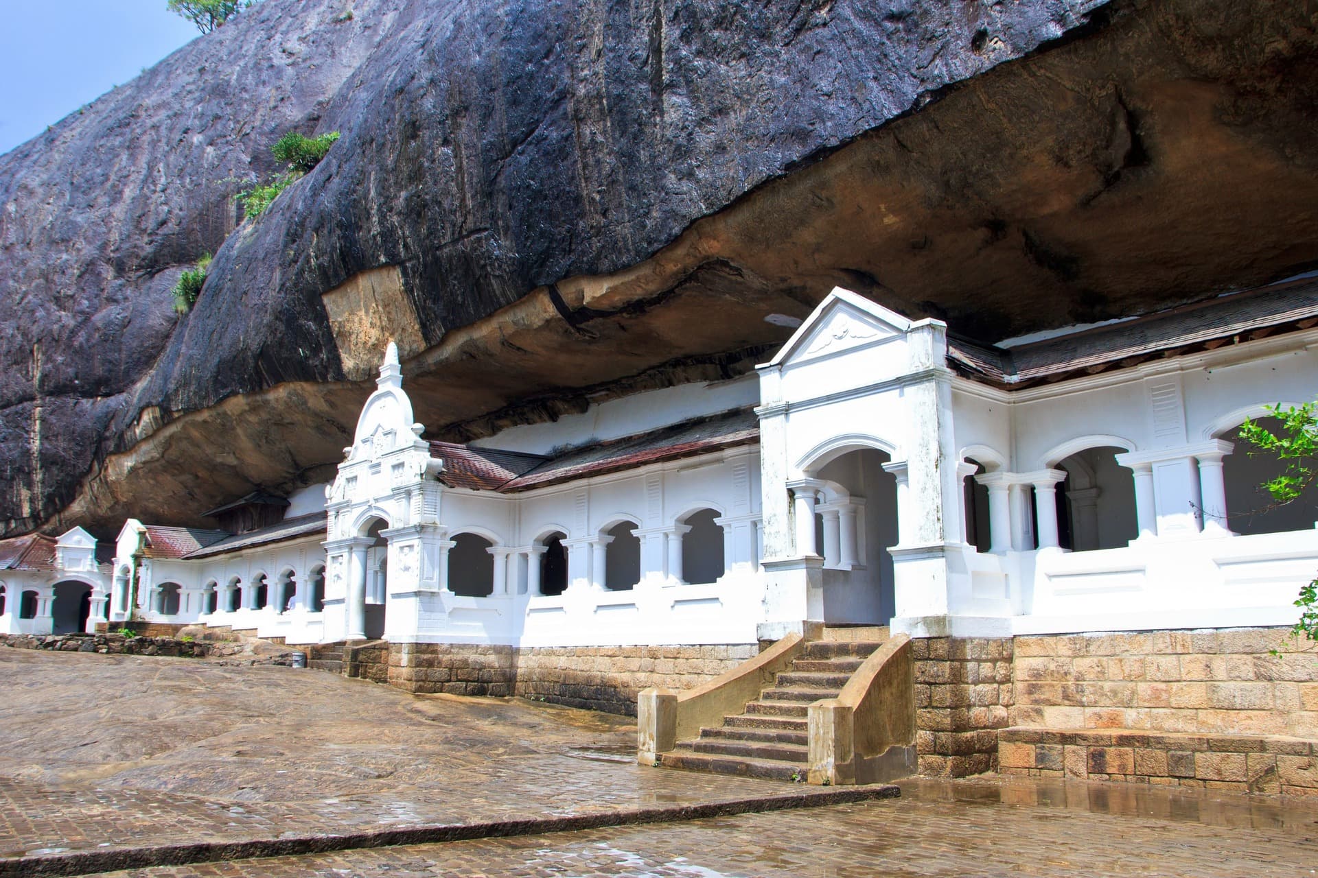 Magnificent Dambulla Cave Temple complex showing golden Buddha statues and ancient cave paintings in atmospheric lighting